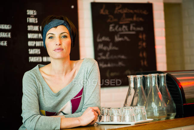 Портрет усміхненої жінки, що стоїть на стійці в ресторані — стокове фото