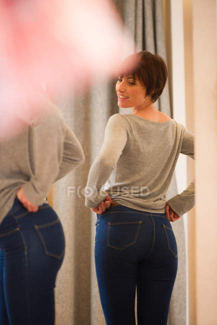Donna che prova i jeans nel camerino — Foto stock