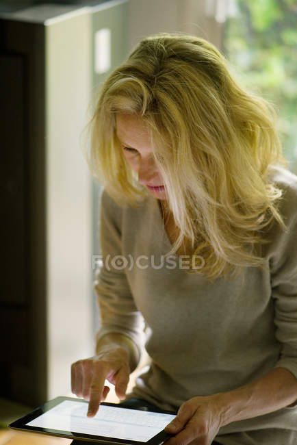 Frau nutzt digitales Tablet zu Hause — Stockfoto