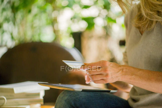 Mulher usando tablet digital e cartão de crédito, tiro recortado — Fotografia de Stock