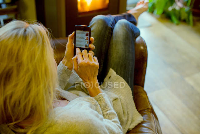 Frau nutzt Smartphone zu Hause — Stockfoto