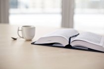 Buch aufschlagen und Kaffee trinken — Stockfoto