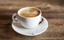 Чашка свіжої кави на дерев'яному столі — стокове фото