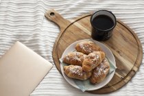 Завтрак и цифровой планшет на простыне — стоковое фото