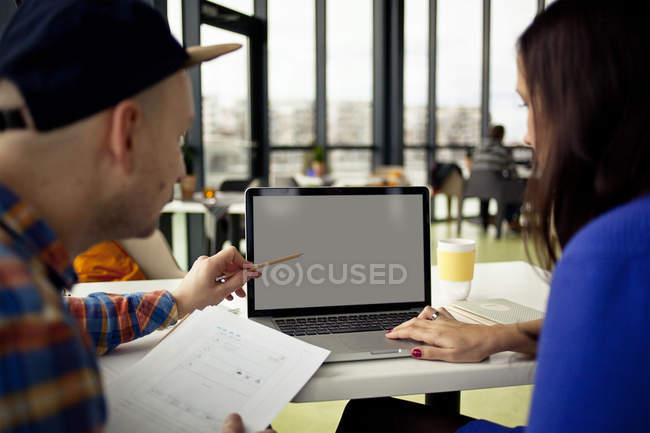 Man and woman at table with laptop — Stock Photo