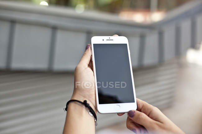 Mãos femininas segurando smartphone — Fotografia de Stock