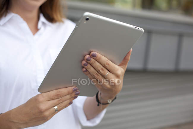 Mani femminili che tengono tablet digitale — Foto stock