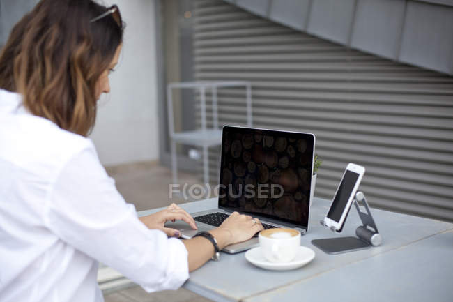 Mujer escribiendo en el teclado del ordenador portátil - foto de stock