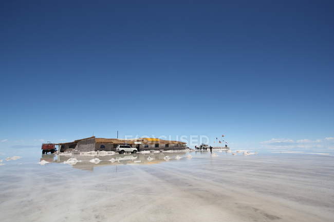 Paisaje con cabaña y autos en vista al desierto boliviano en día soleado, Argentina - foto de stock