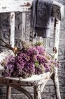 Fresh lilacs on a chair — Stock Photo