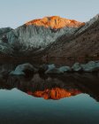 Montanhas iluminadas pelo pôr do sol refletindo em Convict Lake, Califórnia — Fotografia de Stock