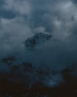 Vista distante delle montagne scure tra le nuvole — Foto stock