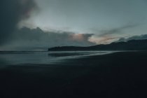 Vista lejana de la playa costera del océano por la noche - foto de stock