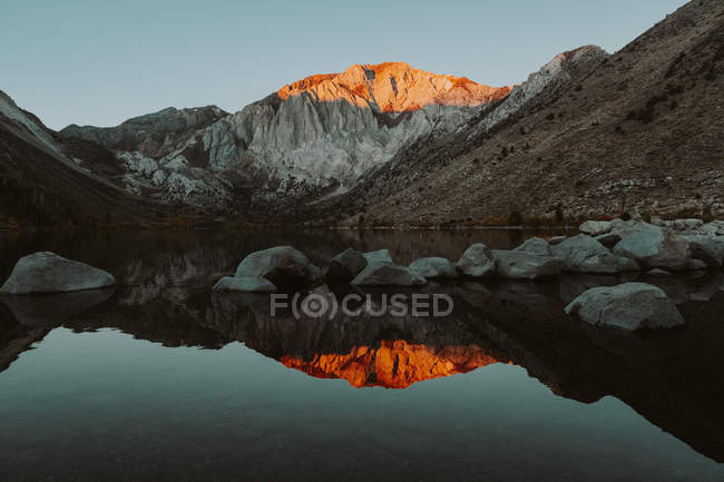 Montagnes éclairées par le coucher du soleil reflétant à Convict Lake, Californie — Photo de stock
