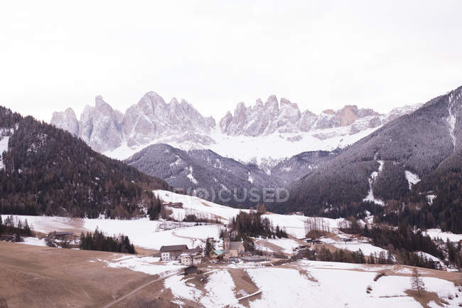 Daytime view of village and snowy mountainscape — Stock Photo
