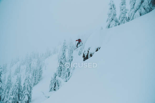 Vista diurna da pessoa de snowboard na encosta da montanha nevada — Fotografia de Stock