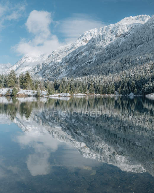 Daytime view of snowy mountains and forest reflected in Gold Creek Pond, Washington — Stock Photo