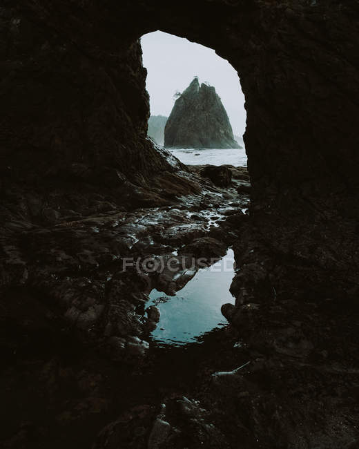 Daytime view of puddle and rocks in mountain cave on Rialto beach, Washington — Stock Photo