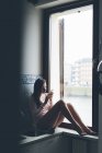 Menina sentada na janela — Fotografia de Stock