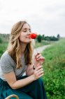 Mädchen riecht rote Blume — Stockfoto