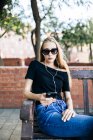 Mädchen mit Sonnenbrille hält Smartphone — Stockfoto