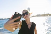 Chica en gafas haciendo selfie - foto de stock