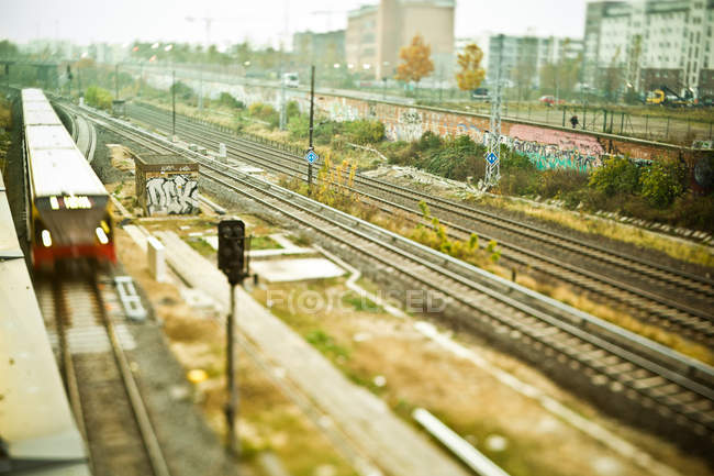 Urban railway with passing train — Stock Photo