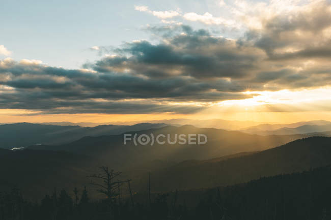 Paisaje nublado en las montañas durante la puesta del sol - foto de stock