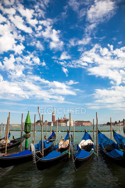 Row of gondolas moored in canal — Stock Photo