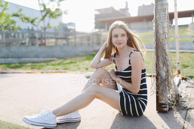 Jeune fille mignonne assise sur le chemin — Photo de stock