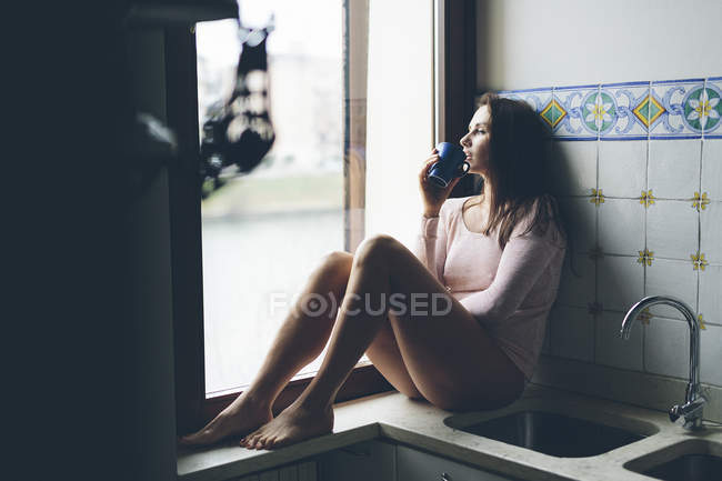 Mädchen sitzt im Fenster — Stockfoto