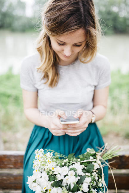 Chica con flores en rodillas - foto de stock