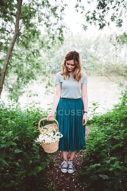 Chica en el bosque contra estanque - foto de stock