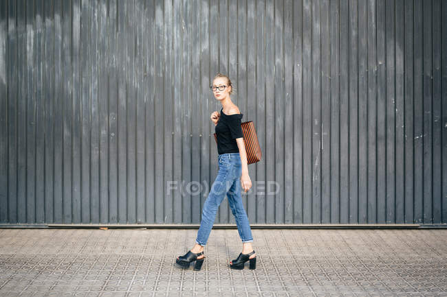Chica caminando con bolso - foto de stock
