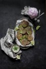 Buñuelos de queso brócoli y salsa de tahini en bandeja en la superficie oscura - foto de stock