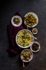 Traditional biryani in bowl with appetizers on black shabby surface — Stock Photo