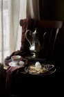 Piatto di formaggio con cracker e chutney sulla sedia con tazza di tè e teiera vintage — Foto stock