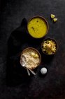 Dal Suppe mit braunem Reis und Kartoffelpüree in Schüsseln auf dunkelgrauer Oberfläche — Stockfoto