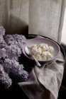 Фруктове морозиво в мисці з фіолетовими бузковими квітами — стокове фото