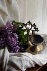 Lilac branch with bronze candlesticks on tray — Stock Photo