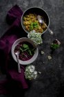 White and black grape jams in bowls on grey surface with violet fabric — Stock Photo