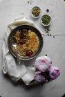 Bol de yaourt à l'avoine et graines sur la table avec des pivoines — Photo de stock