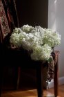 Свіжі вирізані квіти гортензії в дротяному кошику на дерев'яному стільці — стокове фото