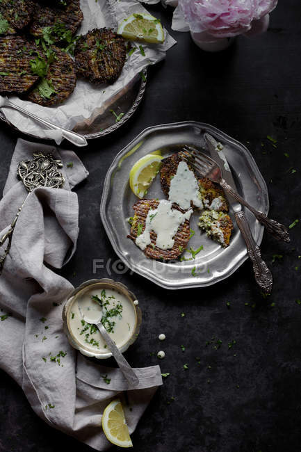 Brokkoli-Käse-Krapfen und Tahini-Sauce im Teller auf dunklem Hintergrund — Stockfoto