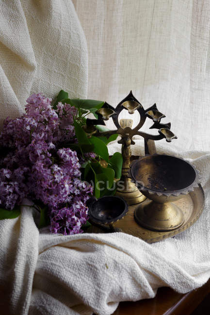 Lilac branch with bronze candlesticks on tray — Stock Photo