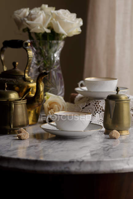 Thé dans des tasses et théière vintage sur plateau en marbre blanc — Photo de stock