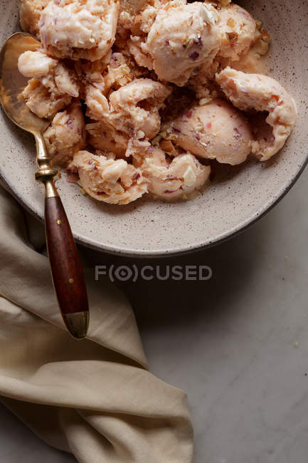 Close-up of peach ice cream in bowl with spoon — Stock Photo