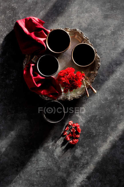 Cups on metal tray with red flowers — Stock Photo