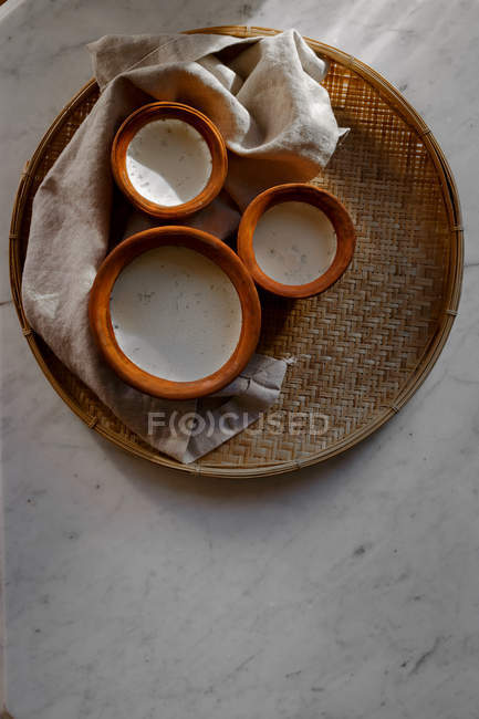Yogur casero en tazones de barro en bandeja - foto de stock