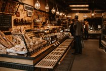 Menschen im Bäckerladen, Theke mit Blick auf das Gebäck im Vordergrund — Stockfoto